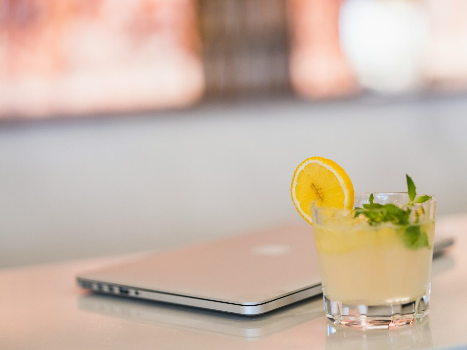 a glass of liquid with a lemon slice on a table